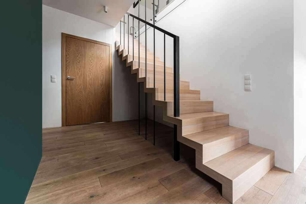 drewniane schody dywanowe z nowoczesną barierką